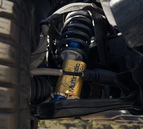Close-up of a vehicle's suspension system featuring a Multimatic DSSV shock absorber.